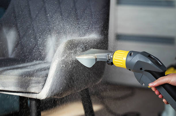 Deep extraction cleaning of a grey fabric armchair.